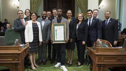 Asm. Aguiar-Curry poses with other legislators to present Jay Rock with an Assembly resolution