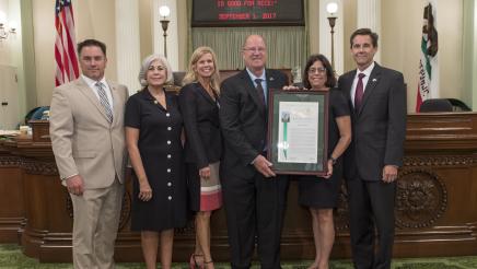 Asm. Aguiar-Curry posing with resolution recipient Ducks Unlimited team members