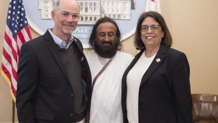 Asm. Aguiar-Curry and longtime partner Larry Harris pose with Sri Sri Ravi Shankar