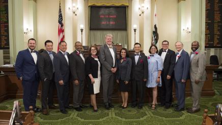 Asm. Aguiar-Curry wears a bow tie to pose with fellow members of the Legislative Bow Tie Caucus