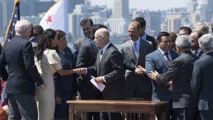 Asm. Aguiar-Curry shakes hands with Gov. Jerry Brown following the signing of AB 398