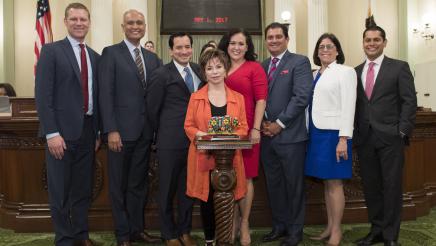 Asm. Aguiar-Curry, along with other members, standing with Latino Spirit Award recipient Isabel Allende