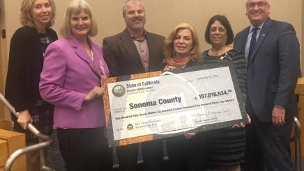 Assemblymember Aguiar-Curry presents check for $157,615,534 to Sonoma County Board of Supervisors - Lynda Hopkins, Susan Gorin, Chair James Gore, Shirlee Zane, David Rabbitt