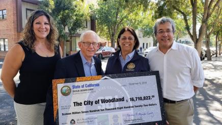 Assemblymember Aguiar-Curry presents check for $16,710,822 to City of Woodland Fiscal Officer Kim McKinney, Councilmember Tom Stallard, and City Manager Paul Navazio