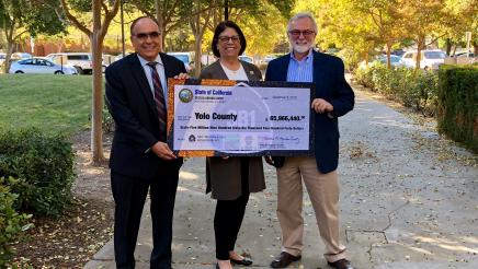 Assemblymember Aguiar-Curry presents check for $65,966,440 to Yolo County Supervisors Jim Provenza and Don Saylor